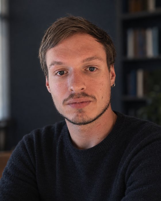 Иван Гринцевич, психолог в Тбилиси, портрет на фоне книжных полок